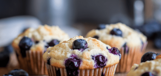 Freshly baked blueberry cottage cheese muffins on a cooling rack, featuring golden tops with bursts of blueberries, perfect for a protein-packed breakfast or snack.